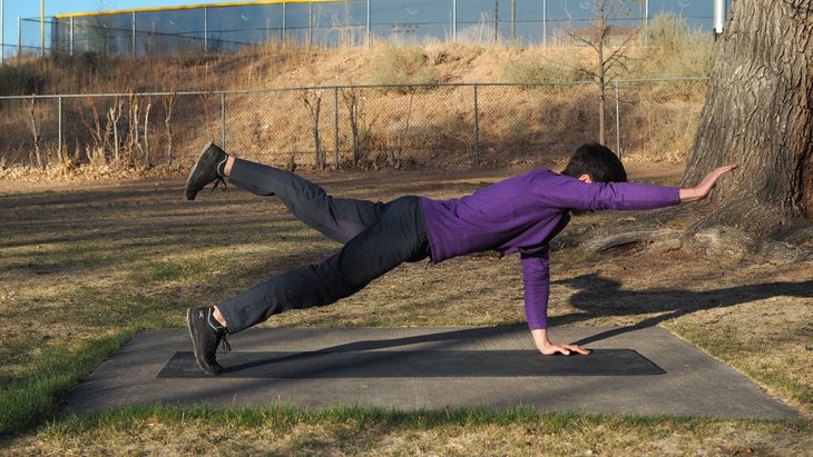 man in plank extending right arm and right leg