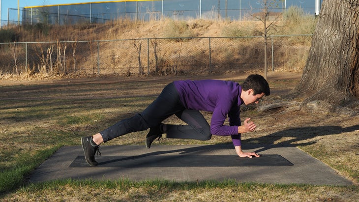 man crunching right leg to right knee beneath him as he hovers over ground