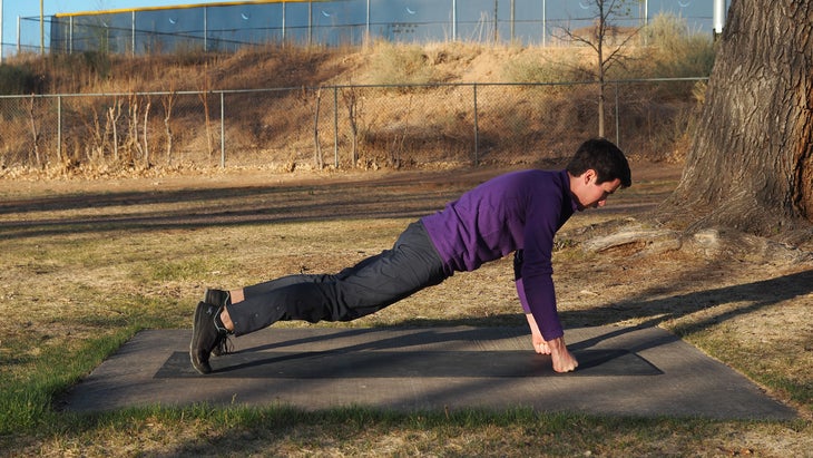 man in a high fist plank