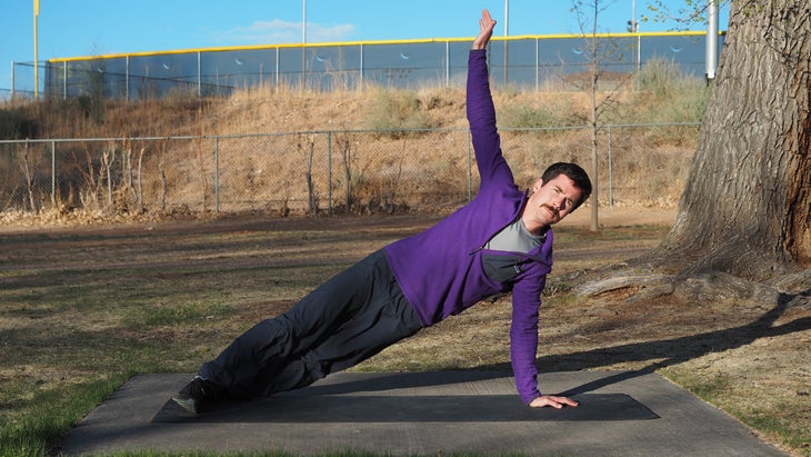 a man balanced with one arm in the air and the other on the ground