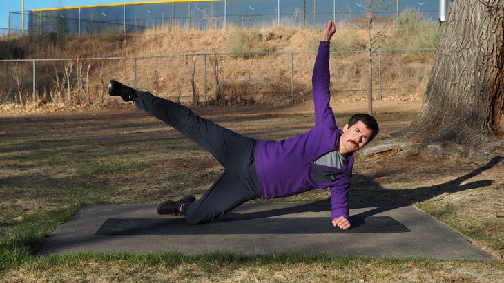 a man with one arm and one leg in the air and the opposite leg and elbow on the ground