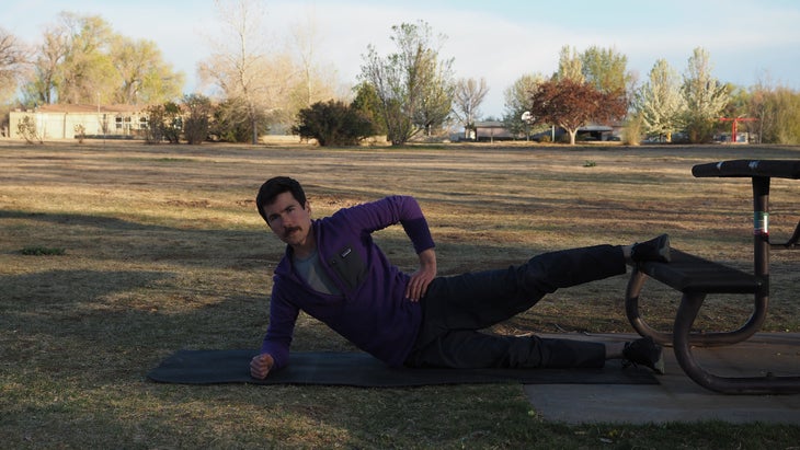 man dipping hip to ground with one leg still on bench