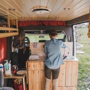 Woman cooking pancakes  in camper van