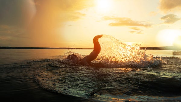 Swimmer conducts training in a lake at sunset