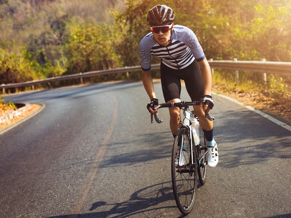 Asian men are cycling road bike in the morning.He is on a forest road.