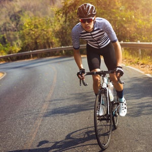 Asian men are cycling road bike in the morning.He is on a forest road.