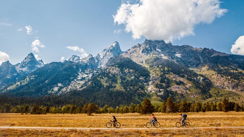 Family Of Cyclists Biking Through Grand Teton National Park's Mountain Range