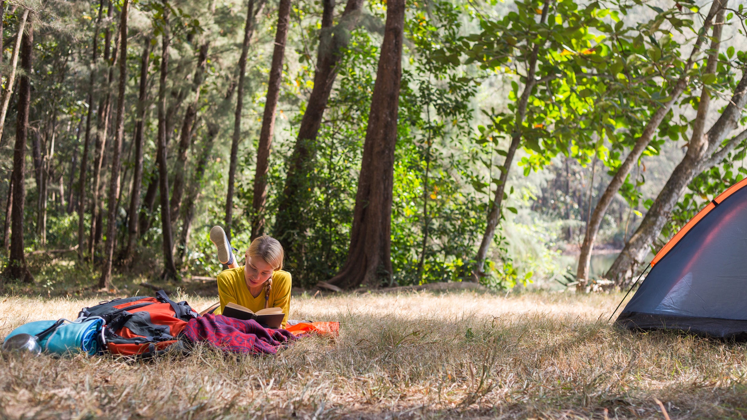 Woman Reading Book Next To The Tent