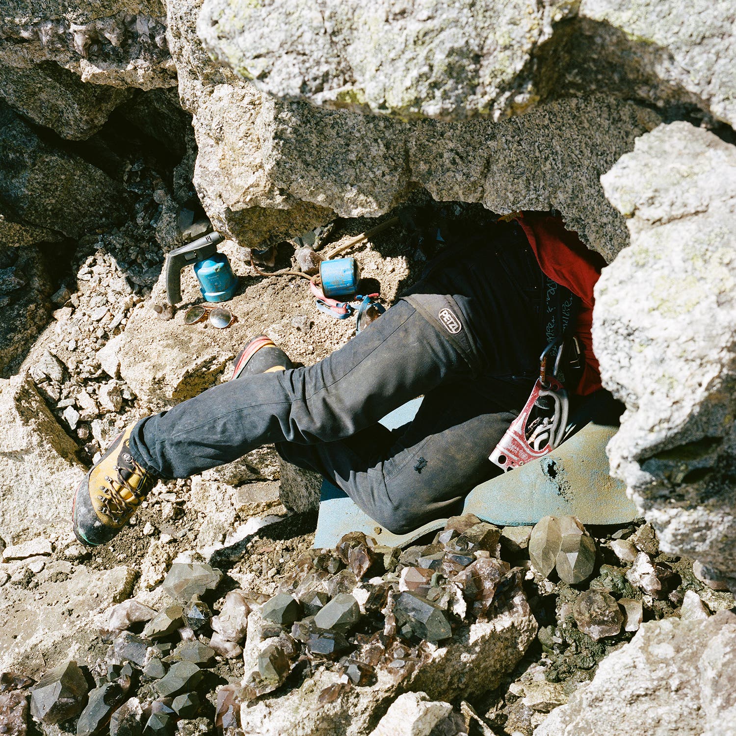 Péray crawls into a pocket on the south face of Les Courtes to extract crystals.