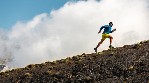 Sportsman Running In Mountains On Foggy Day