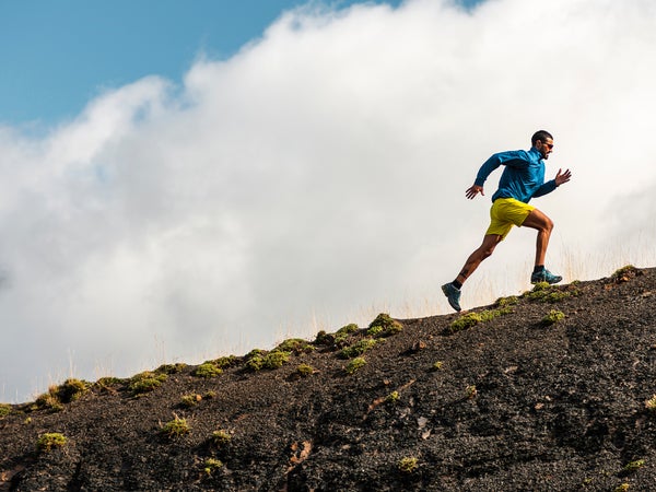 Sportsman Running In Mountains On Foggy Day