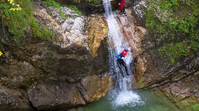 Canyoning in a narrow gorge filled with rapids, pools and waterfalls in the Soca valley near Bovec, Slovenia.