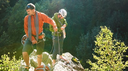 Two rock climbers standing on rocks in sunlight, Chamonix, Haute Savoie, France