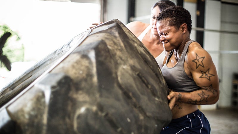 women doing tire-flip exercise