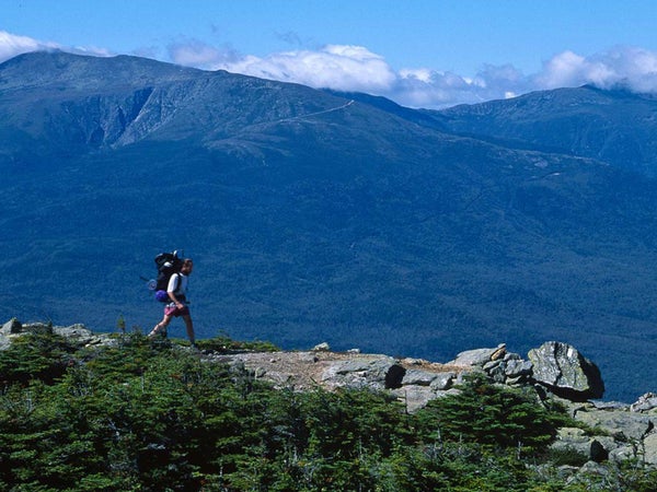 An AT hiker on Height Mountain (with Mount Washington in the background) in New Hampshire’s White Mountains