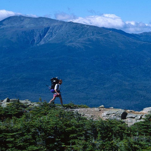 An AT hiker on Height Mountain (with Mount Washington in the background) in New Hampshire’s White Mountains