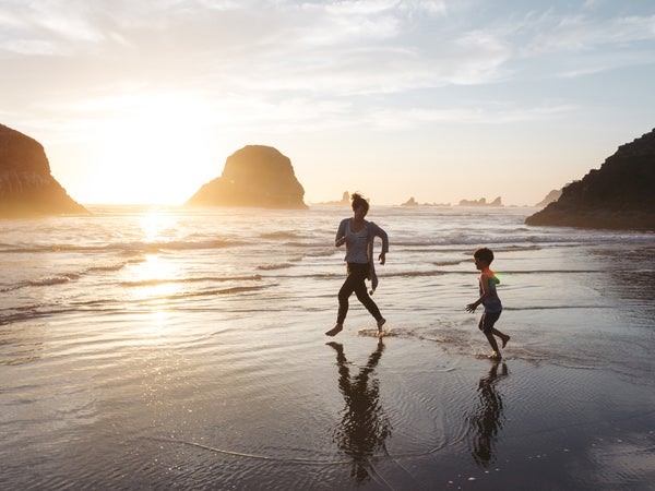 Mom Playing With Kid At The Beach.