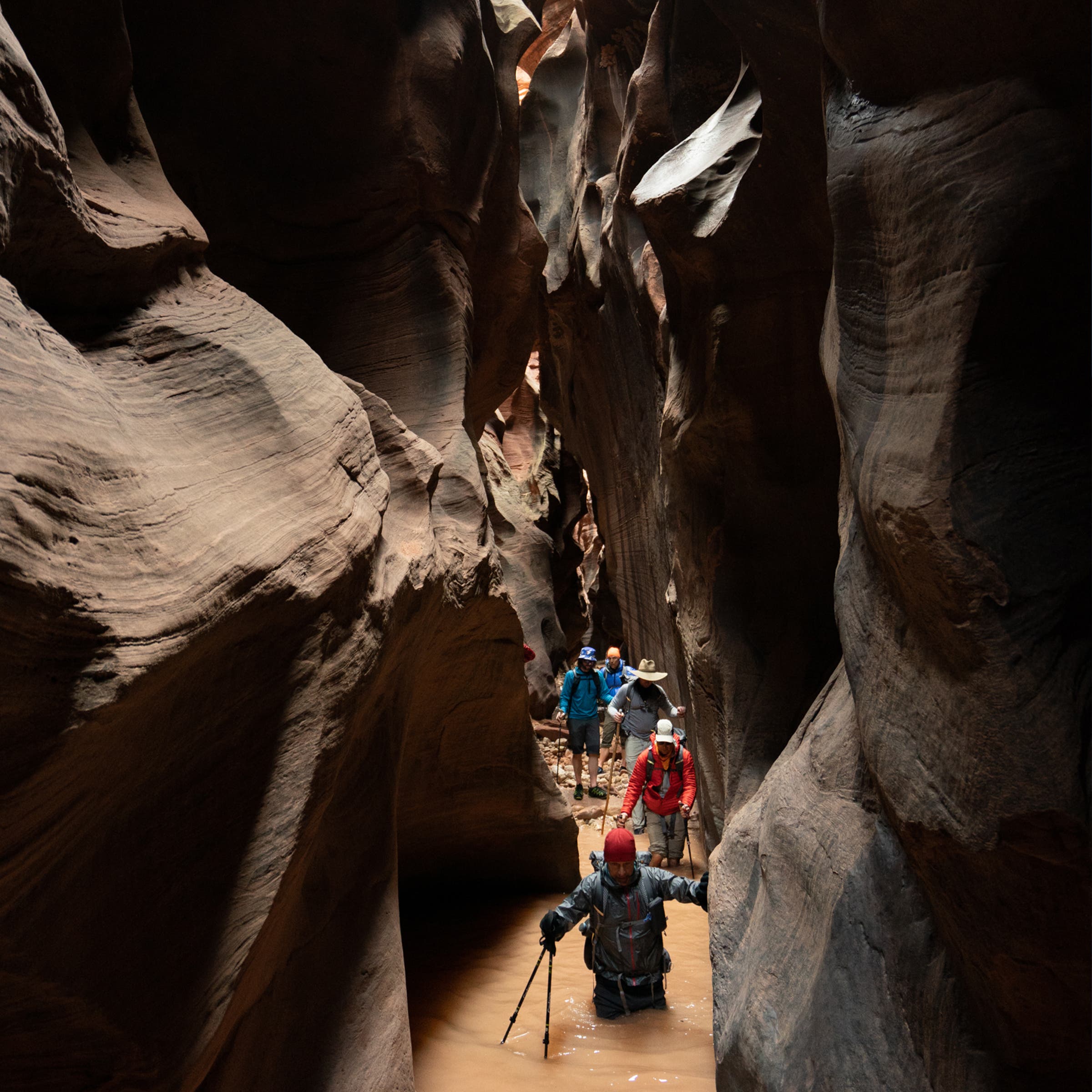 Ali Selim, the author, makes his way through waist deep ice cold water in the slot canyon.