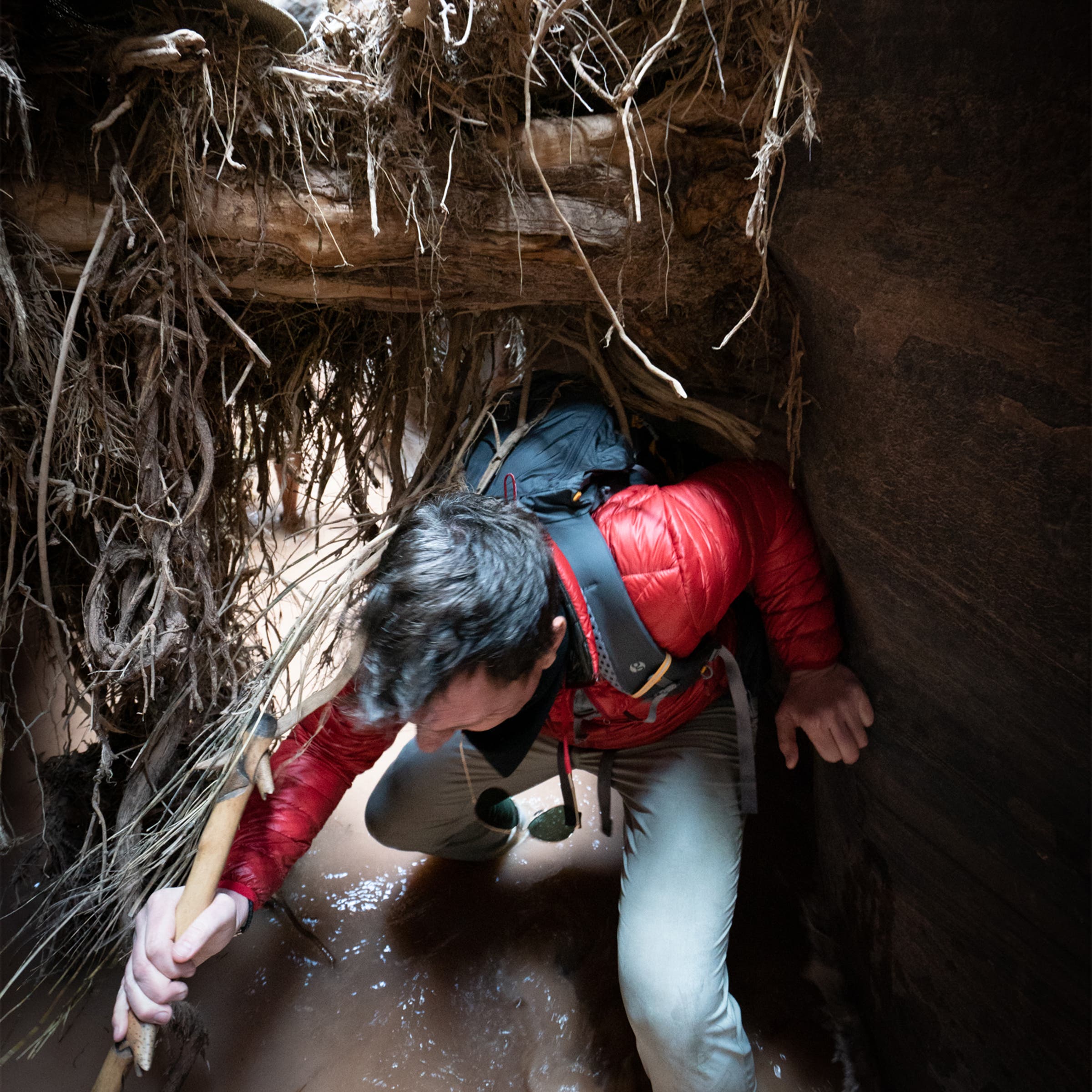 Bill Weir makes his way under flood debris trapped in the canyon.