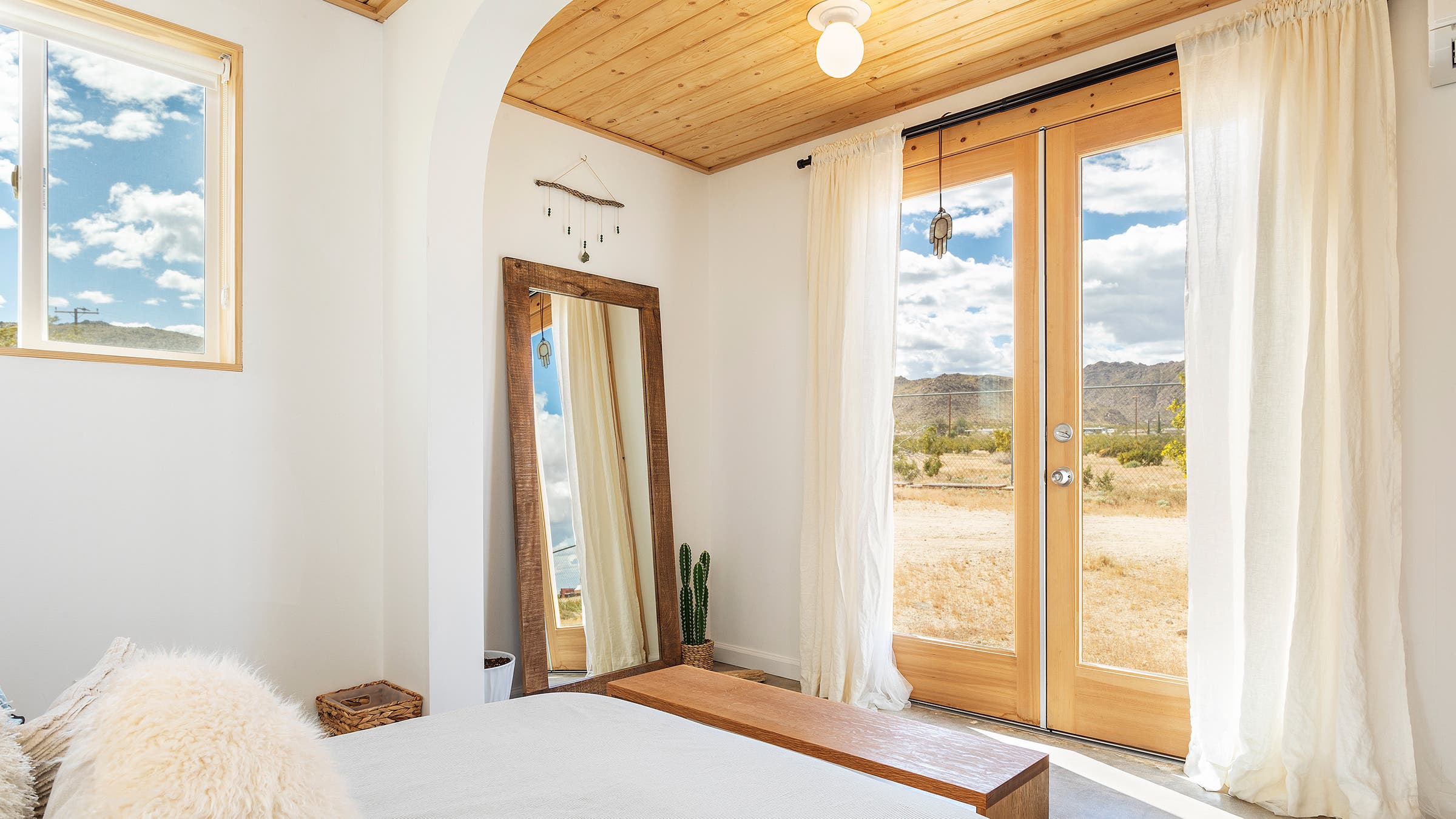 white airy bedroom looking out onto the desert