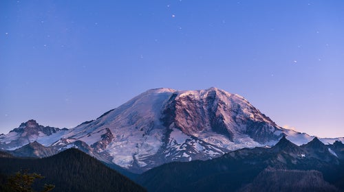 Scenic view of snowcapped mountain against blue sky at dusk