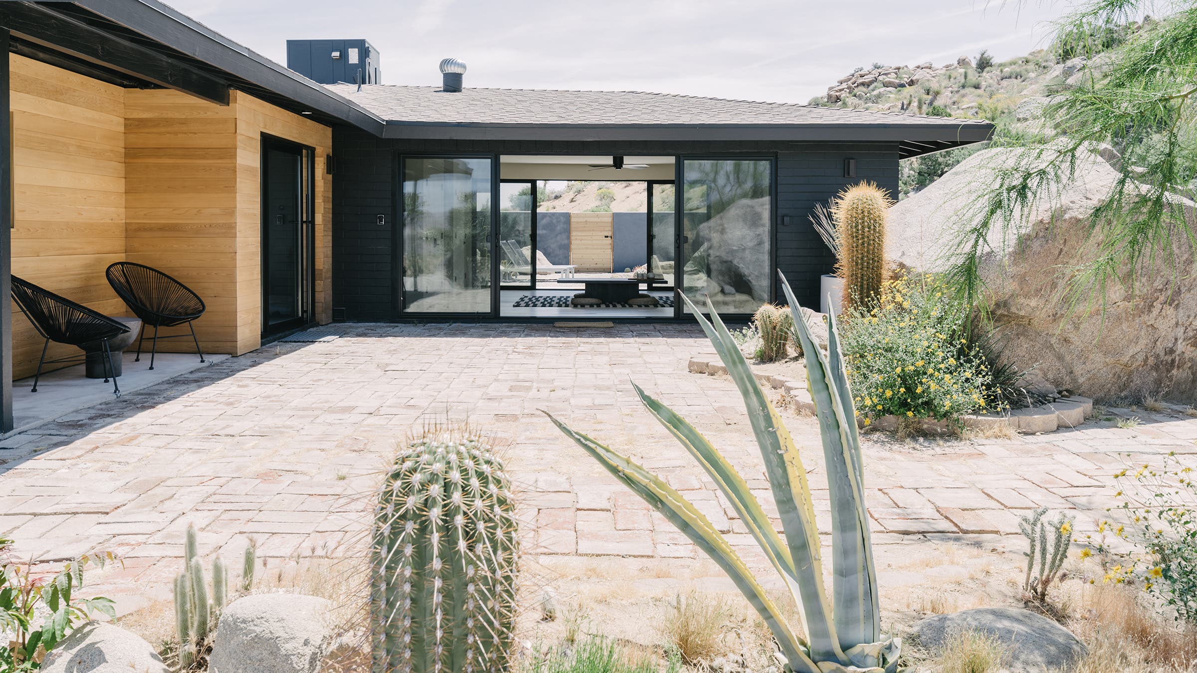 modern black and wood home with desert landscape