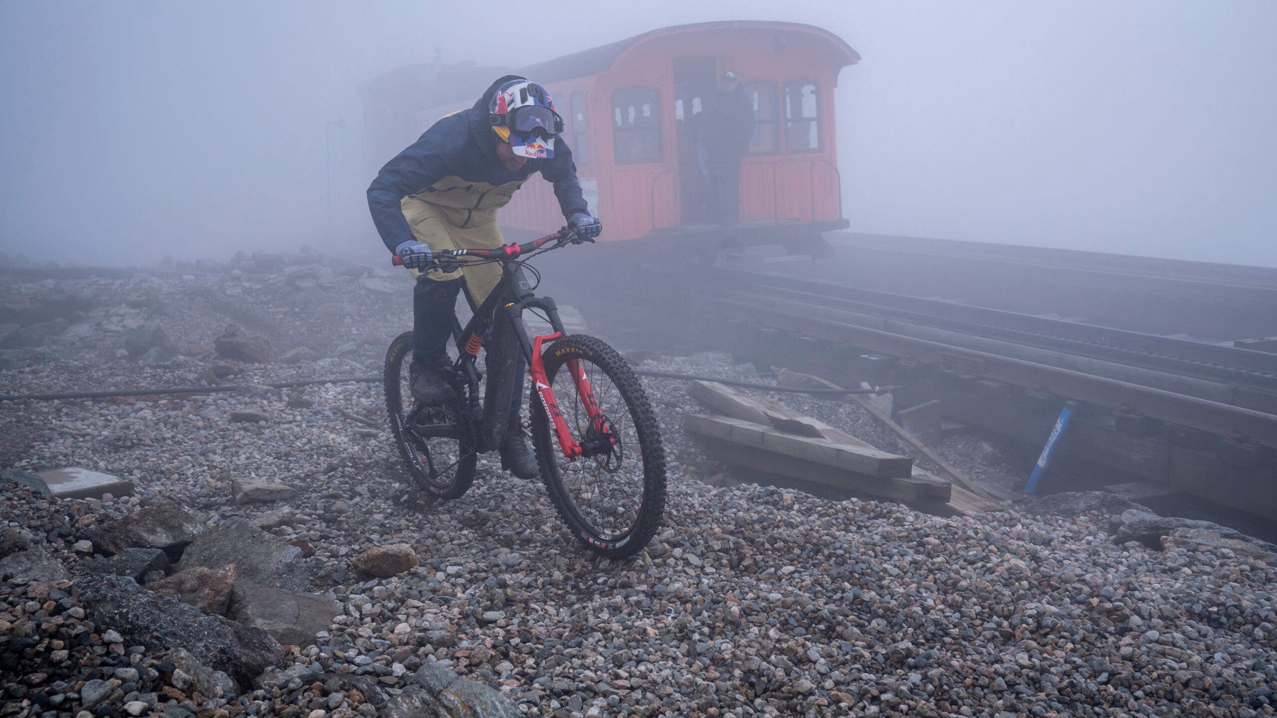 Aaron Chases riding next to a cog railway car in fog