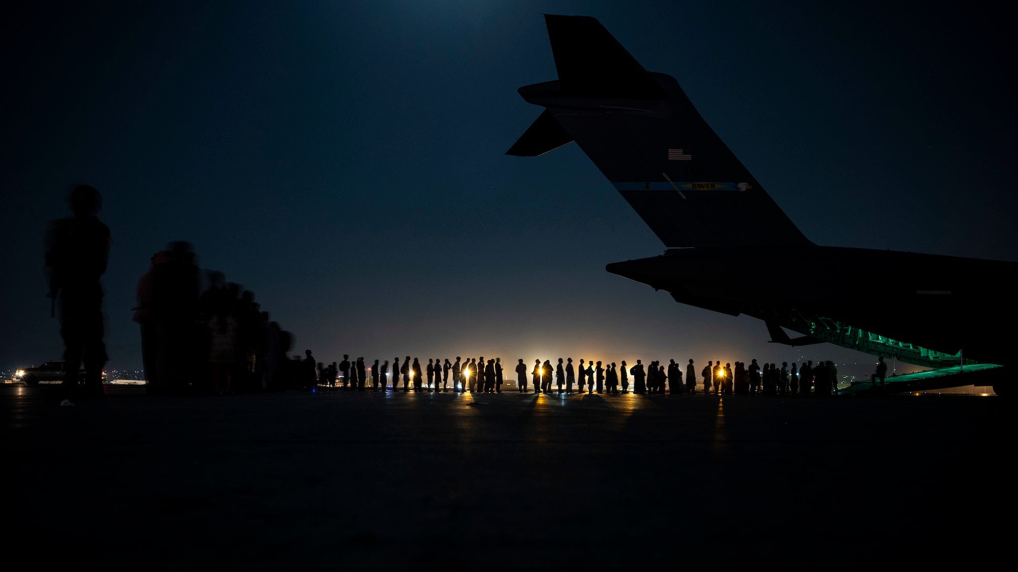 A U.S. Air Force aircrew, assigned to the 816th Expeditionary Airlift Squadron, prepare to load qualified evacuees aboard a U.S. Air Force C-17 Globemaster III aircraft in support of Afghanistan evacuation at Hamid Karzai International Airport, Afghanistan, Aug. 21, 2021. The Department of Defense is committed to supporting the U.S. State Department in the departure of U.S. and allied civilian personnel from Afghanistan, and to evacuate Afghan allies safely. (U.S. Air Force photo by Senior Airman Taylor Crul)