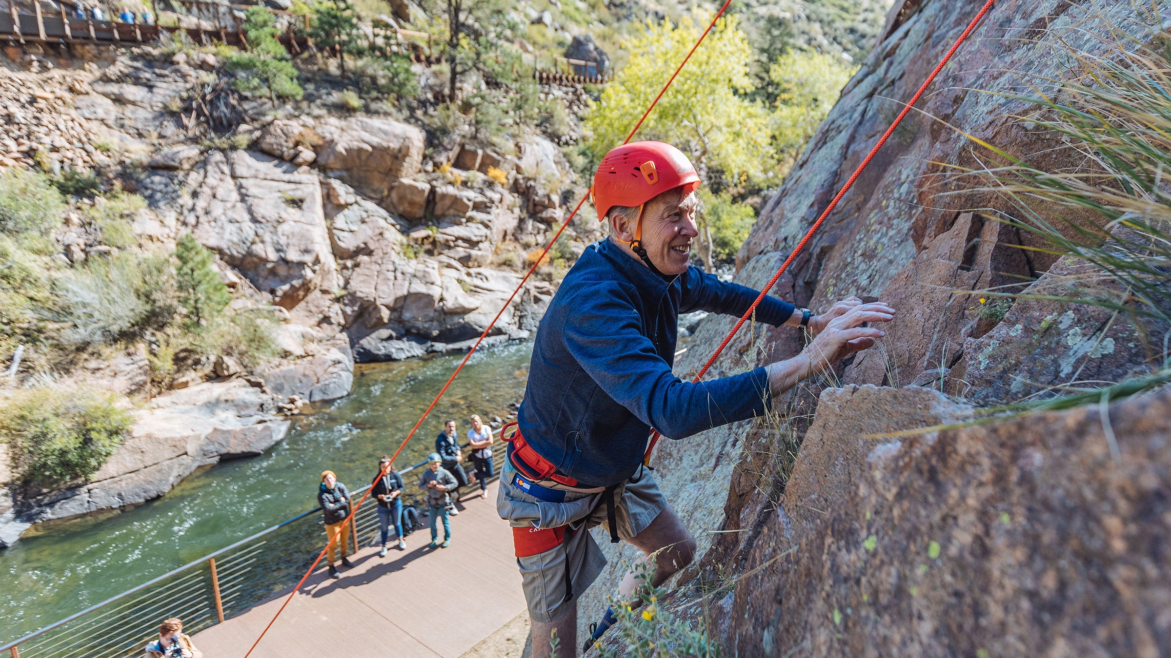 Senator John Hickenlooper climbs a crag over Clear Creek Canyon in Golden, Colorado.
