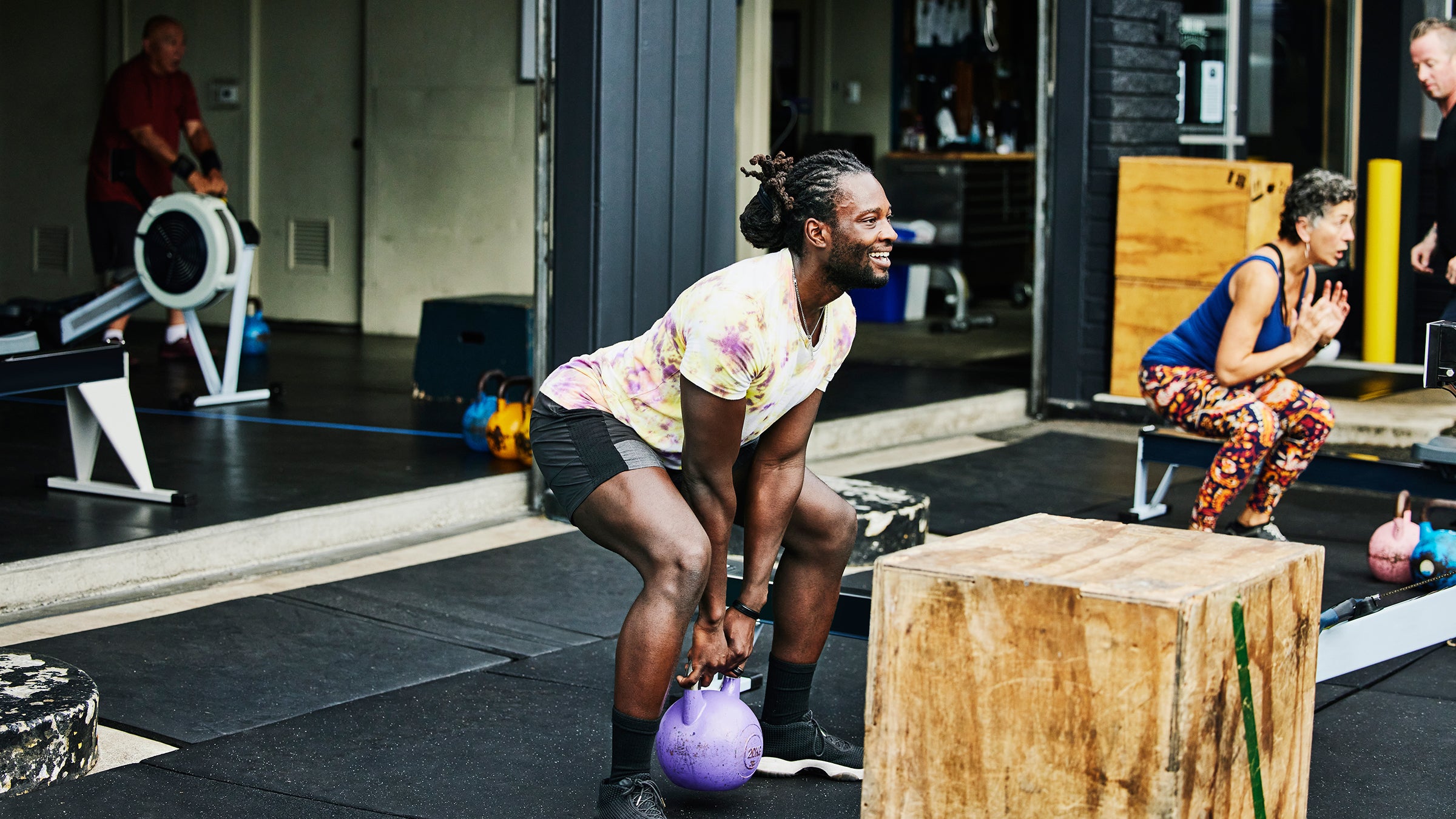 Man doing kettlebell squats during workout at outdoor gym