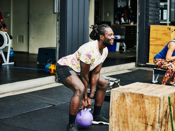 Man doing kettlebell squats during workout at outdoor gym