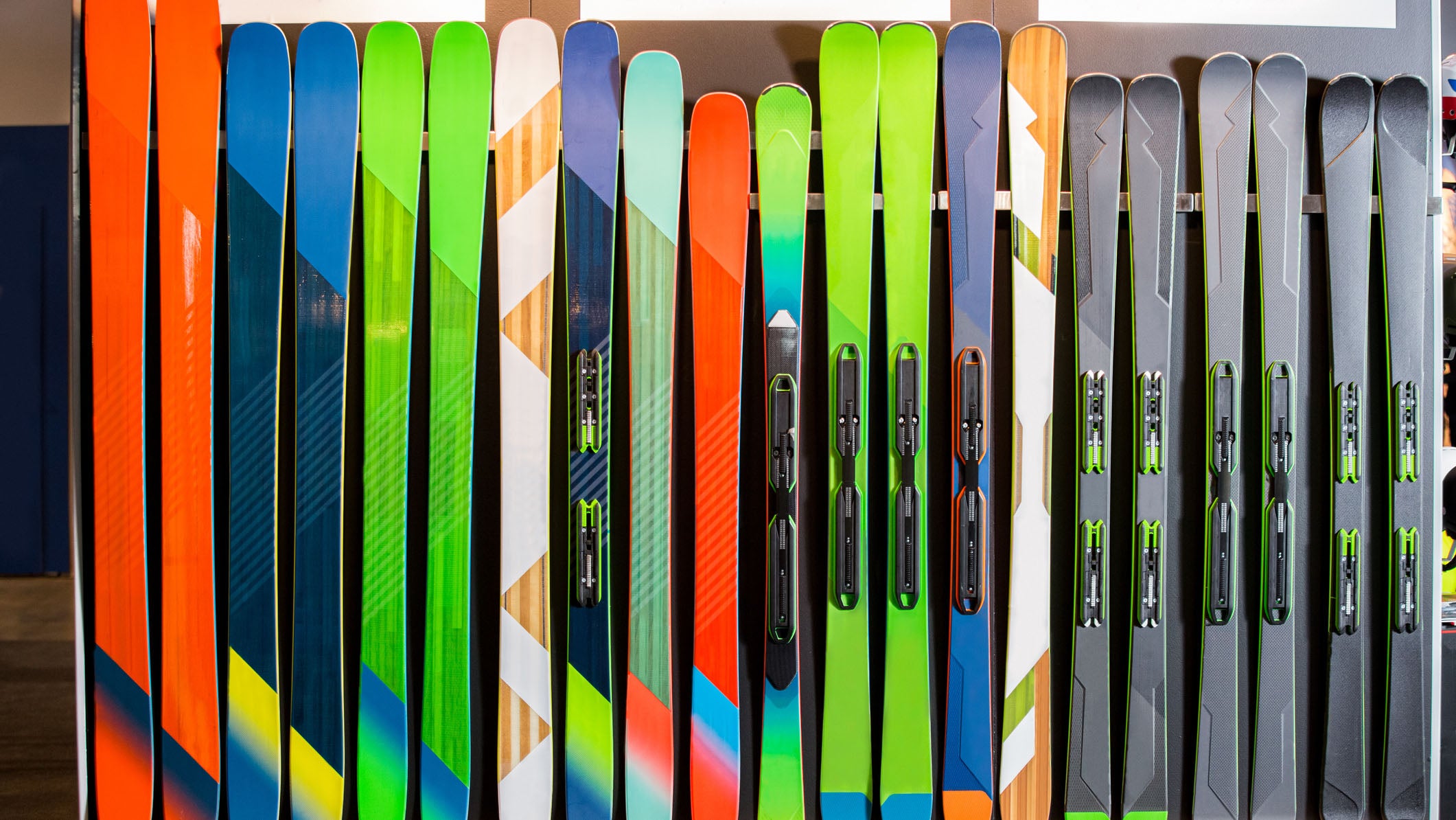 Ski shop sale. Rows of colourful skis on wall.