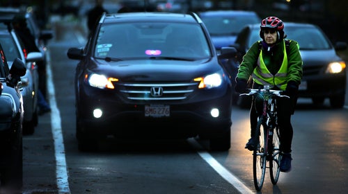 With a Lyft/Uber driver blocking the bike lane waiting for a passenger, a cyclist slows Beacon Street traffic in Brookline, MA
