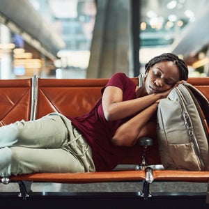 a young woman falling asleep at the airport