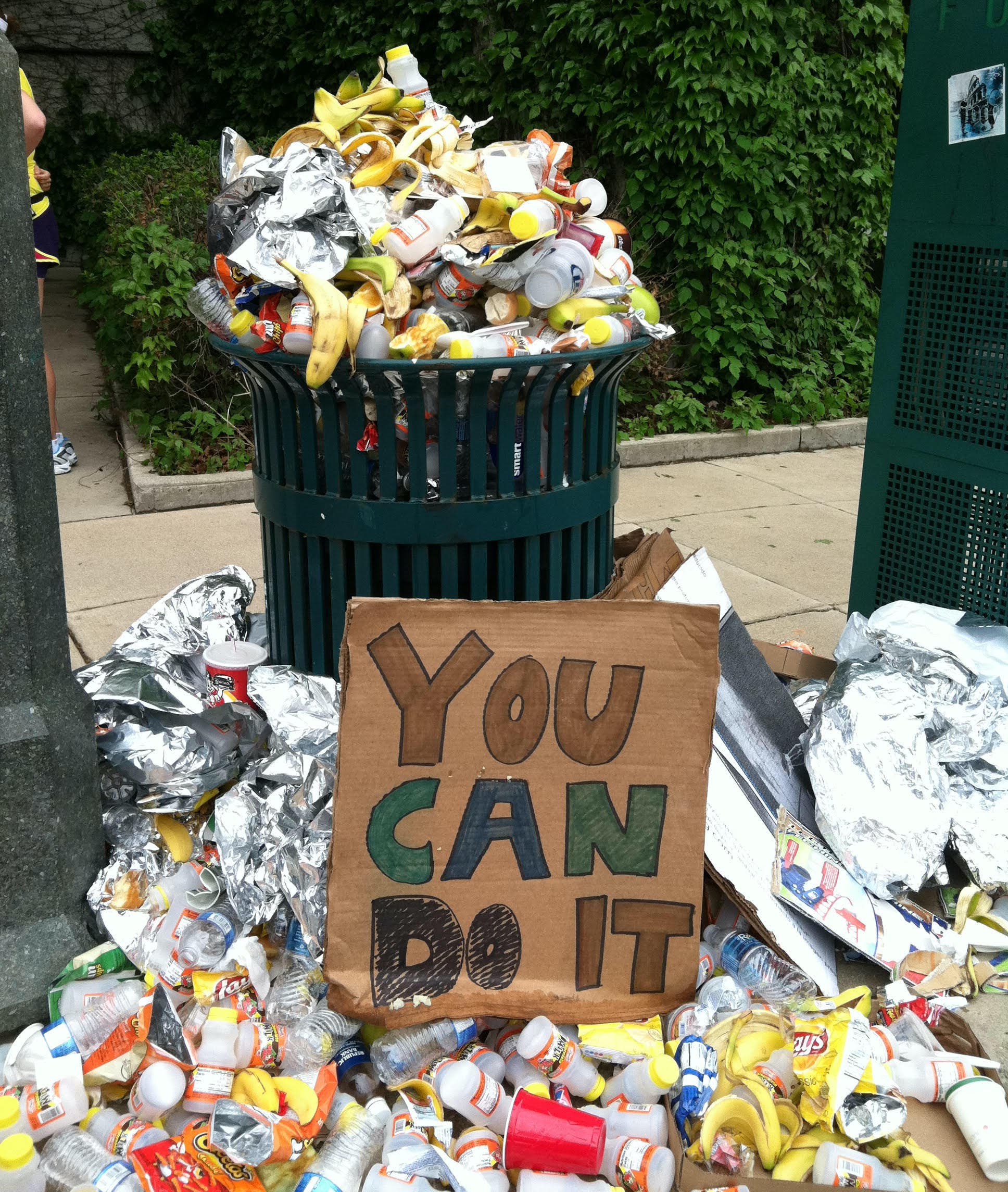 A garbage bin filled with cups and banana peels.