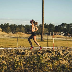 Woman running in summer on grassy feild.