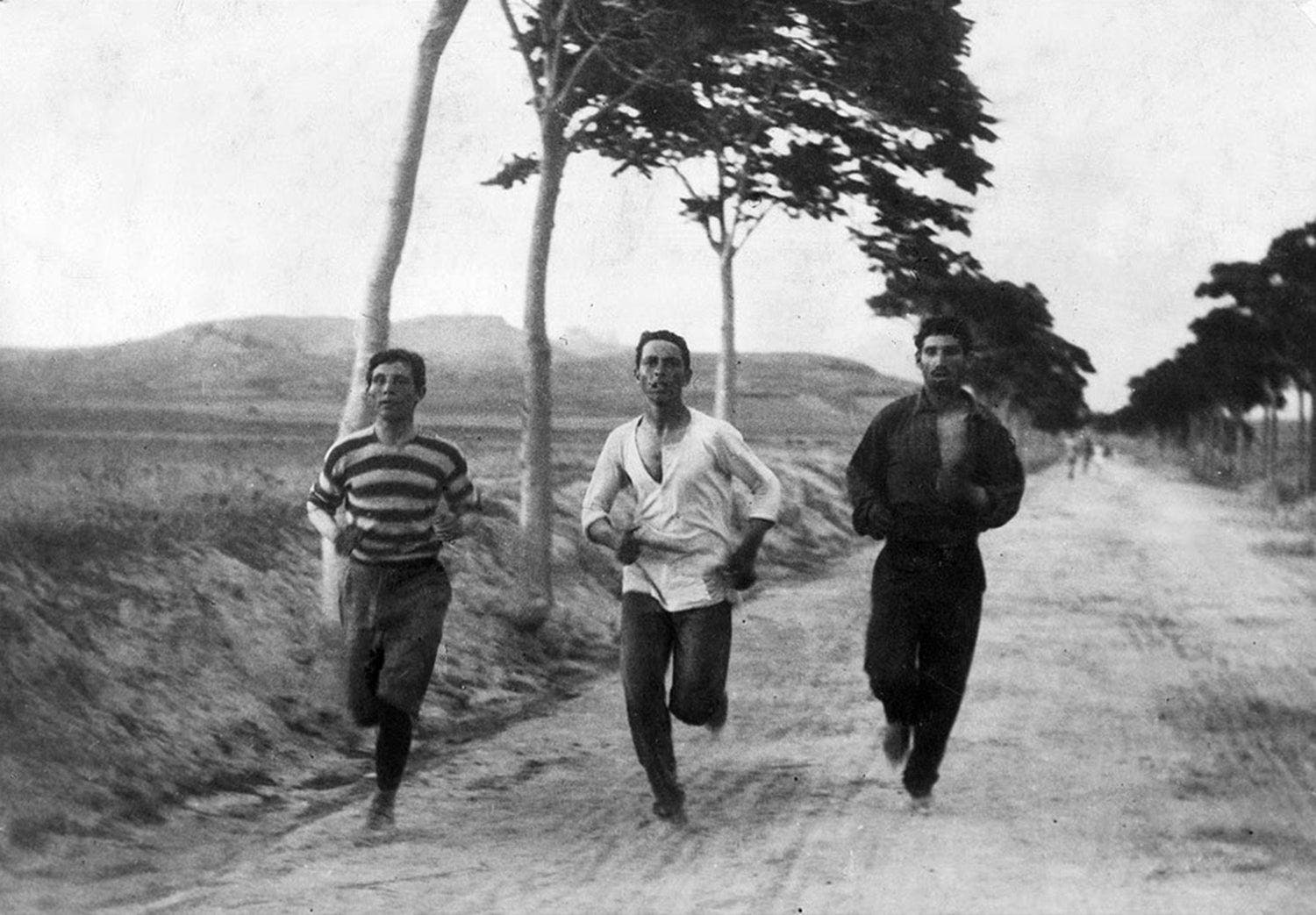 Three athletes in training for the marathon race of the 1896 Athens Olympic Games, on the road from Marathon, Greece, Vasilakos in the middle.
