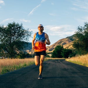 Jared Ward running in summer on black road.