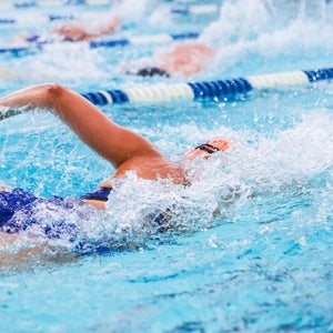 Woman in mid-stroke in pool swim lane