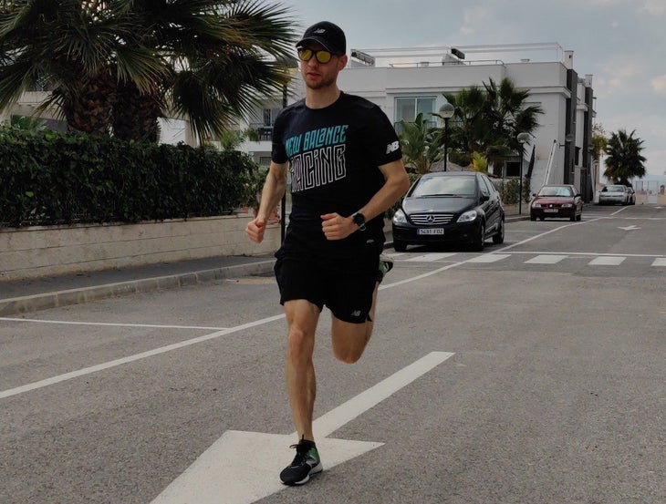 Antti-Pekka Niinistö running on a road lined with palm trees.