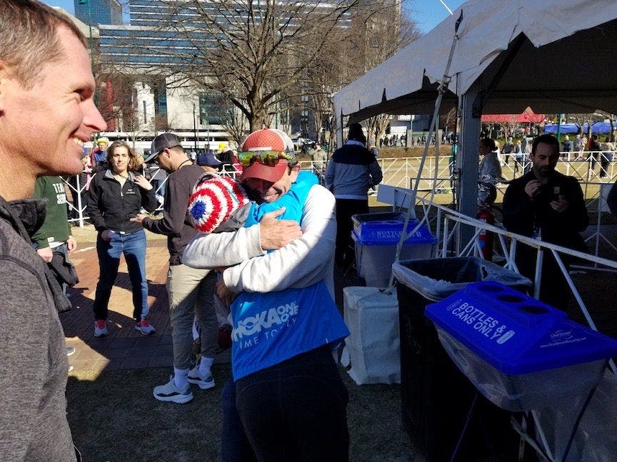 Coach Ben Rosario and runner Aliphine hug post marathon trial race