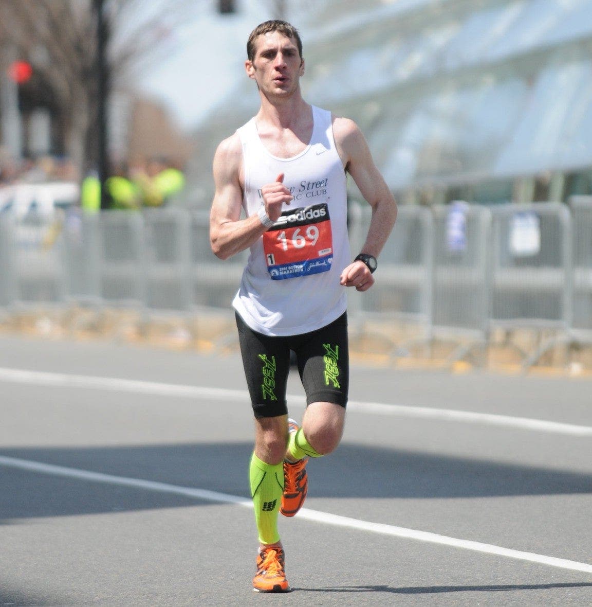 Runner racing in a road marathon in a white jersey. 