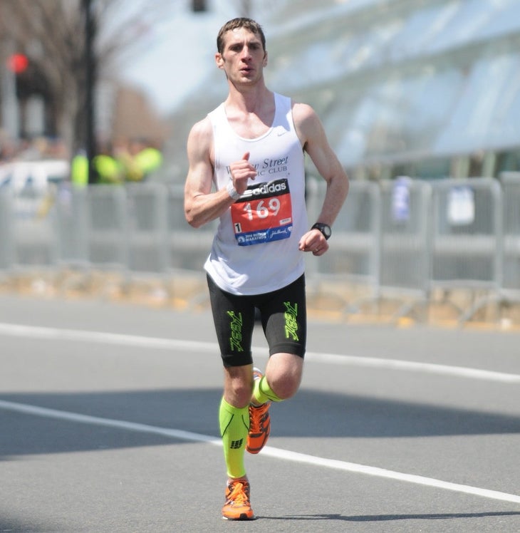 Runner racing in a road marathon in a white jersey. 