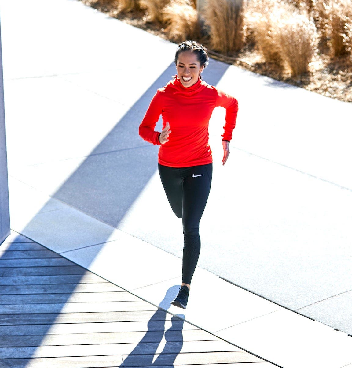 Women running over a bridge on a sunny day.