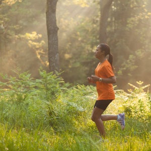 Woman running through woods