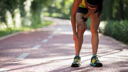Female runner suffering from shin splints injury.