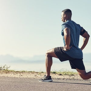 Shot of a young man doing lunges outdoors.