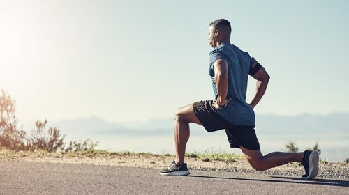 Shot of a young man doing lunges outdoors.
