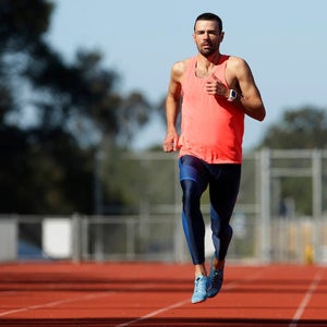 A male runner trains on a track on a sunny day in San Diego, California.