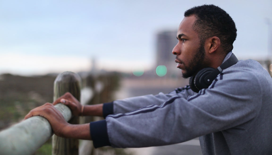 A man resting against a fence post.